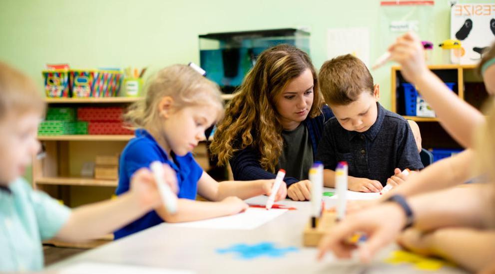 Student teacher working with children in classroom